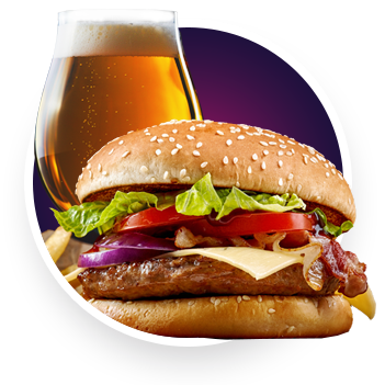 A sesame seed burger with lettuce, tomato, onion, cheese, and bacon sits in front of a glass of beer—perfect fuel for an exciting night of poker at the Great Canadian Casino Vancouver, with a few fries tempting you in the background.